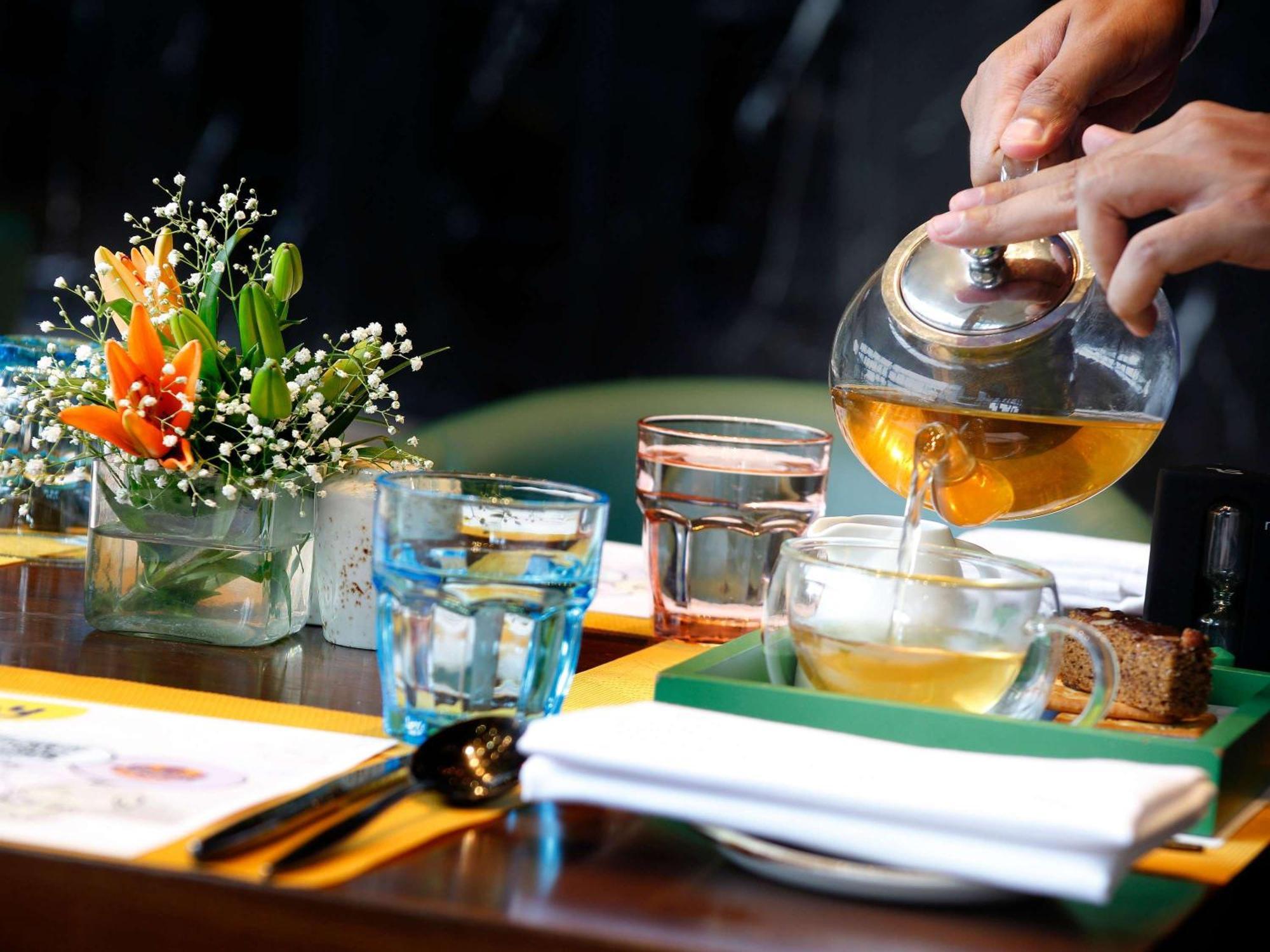 Novotel Kolkata Hotel And Residences Exterior photo A server pours tea at a restaurant